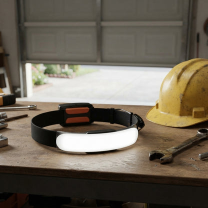 Camping headlamp on a workbench beside a hard hat and wrench