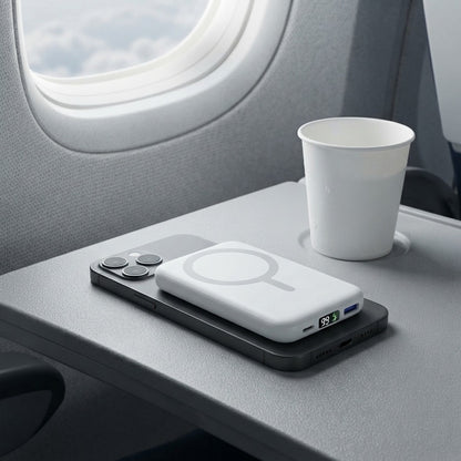 Magnetic power bank attached to a phone on an aircraft tray table