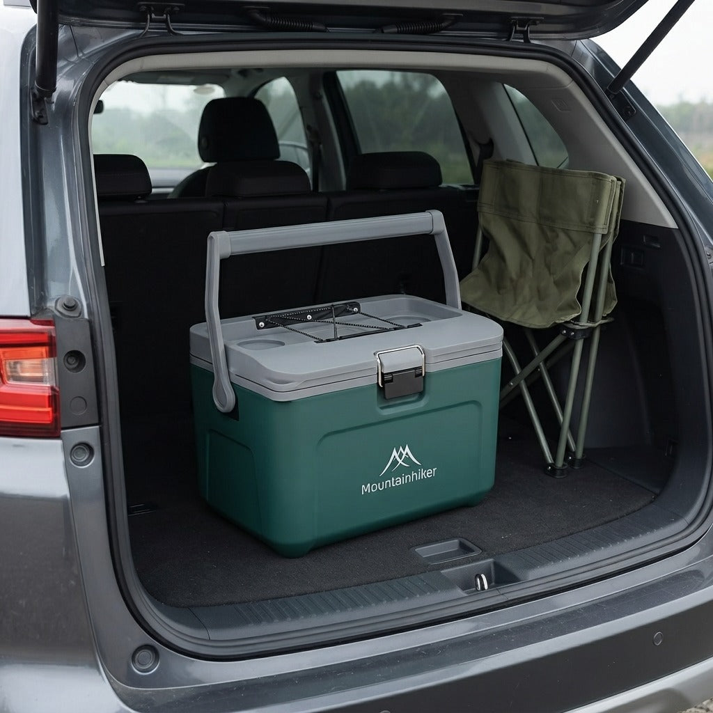 Green hard cooler box loaded in a car boot beside a folded camping chair