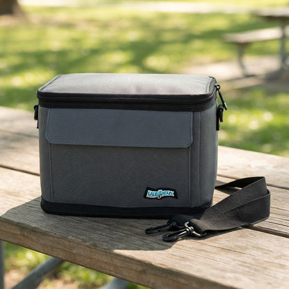 Soft cooler lunch bag zipped shut on a picnic table with the strap alongside